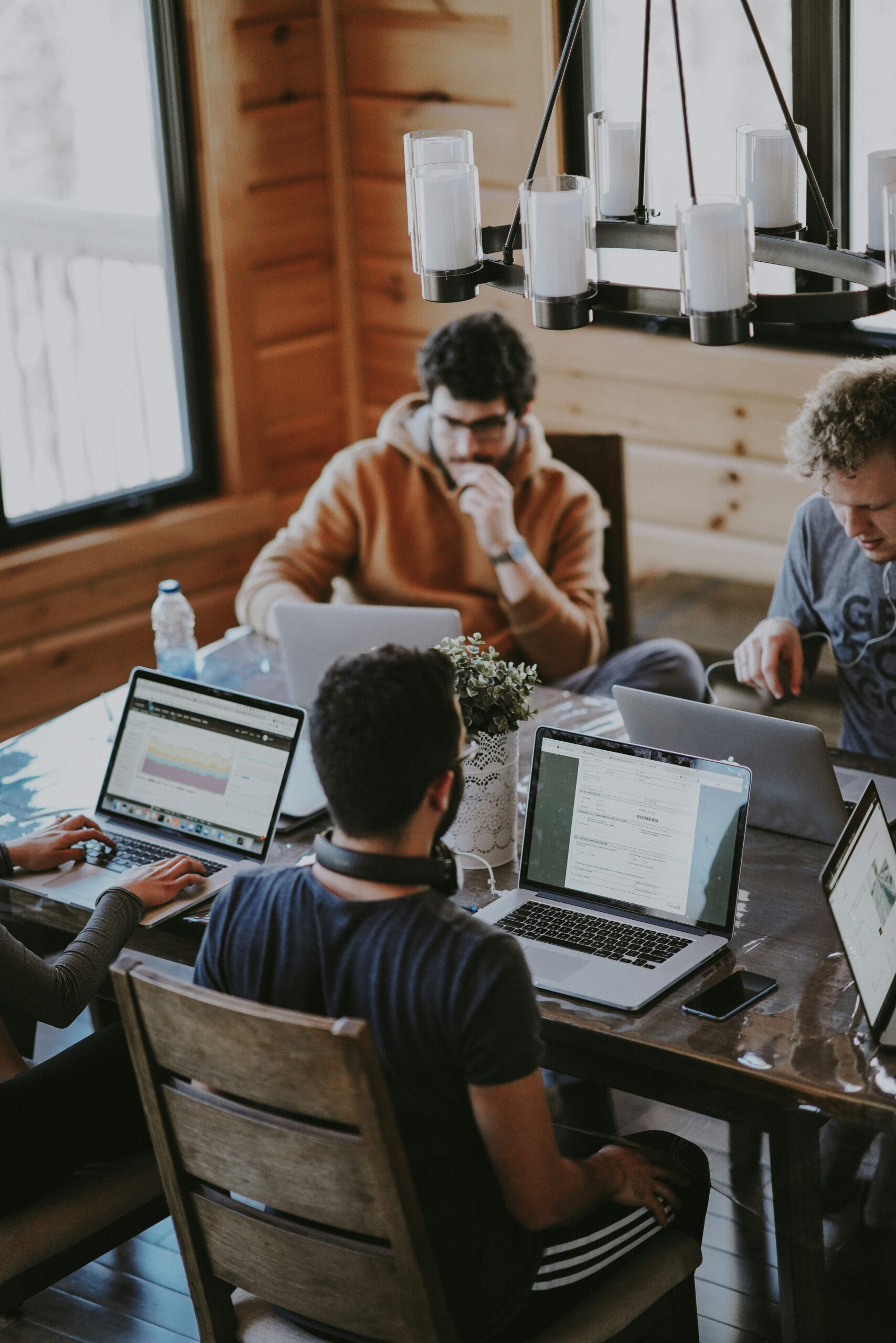 In a contemporary workspace, a group of professionals are working together on computers during a discussion about digital marketing and strategy.